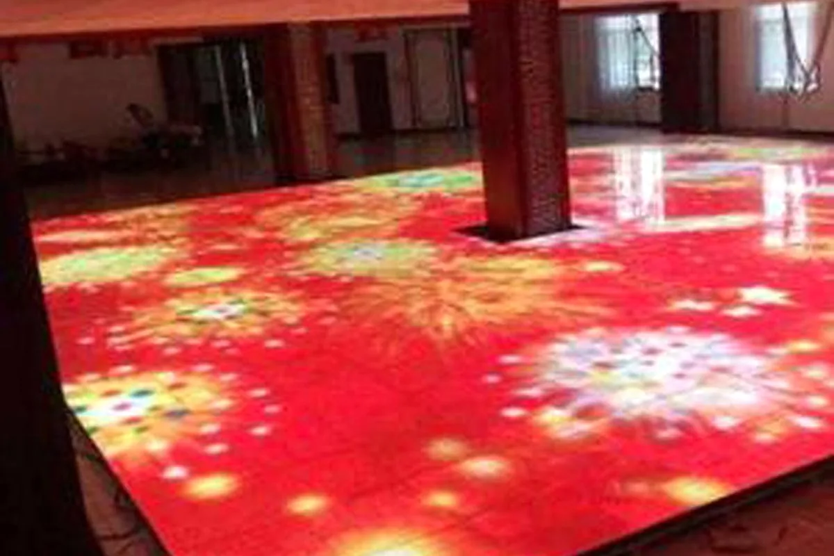 Baldosas LED de suelo interactivas mostrando un patrón floral rojo